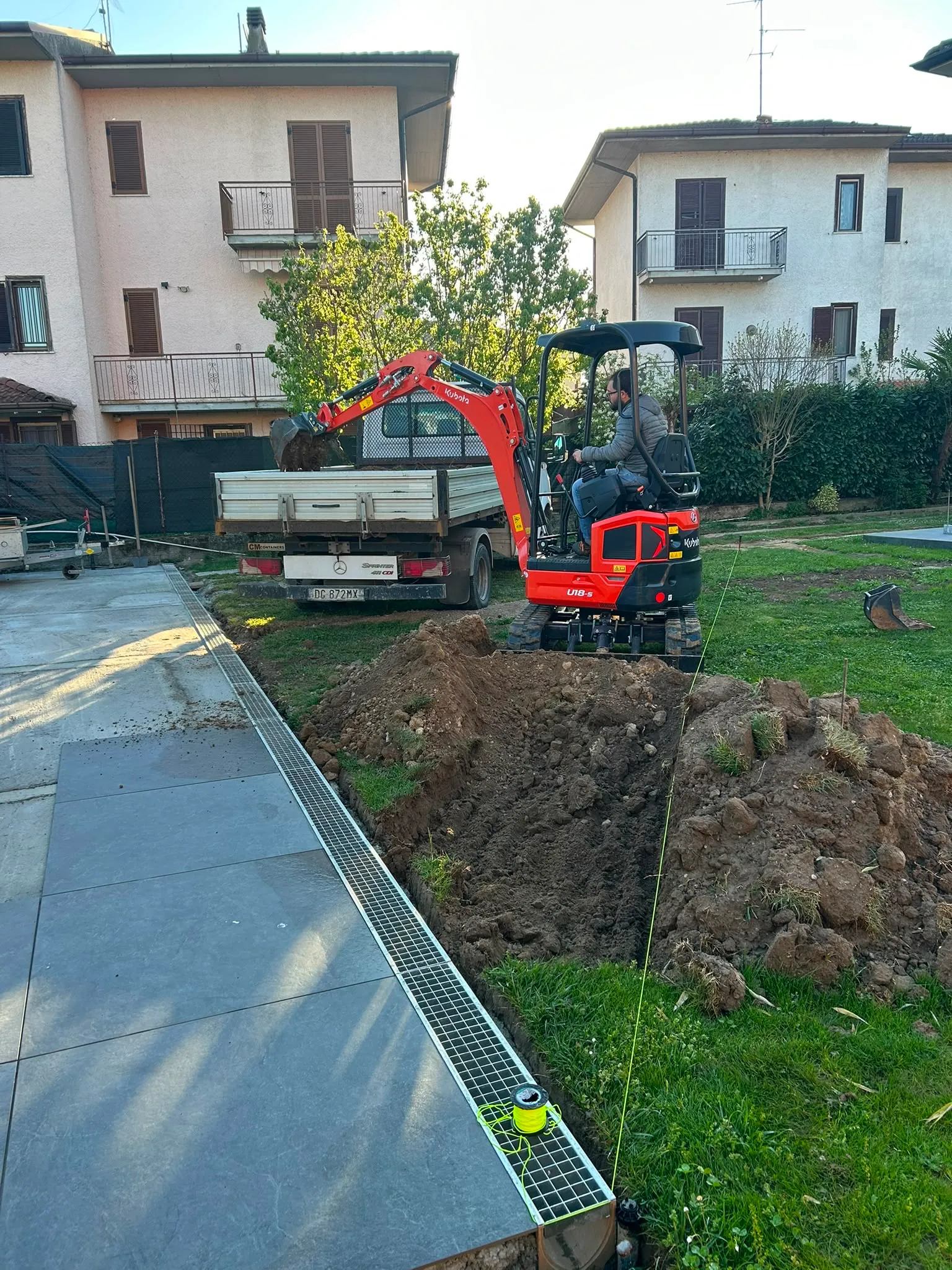 Carico terra in giardino con mini escavatore