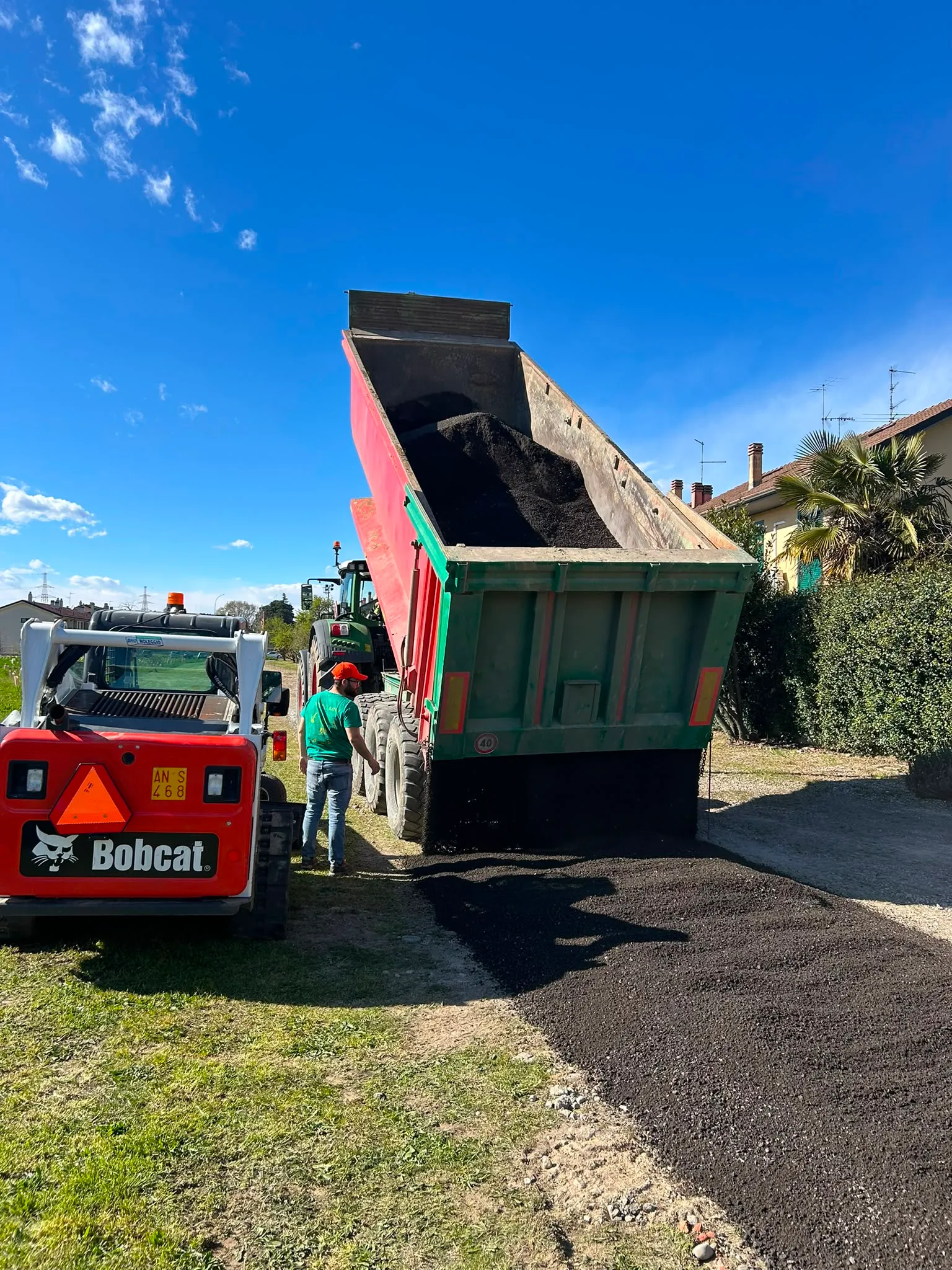 Carico della terra su autocarro con minipala