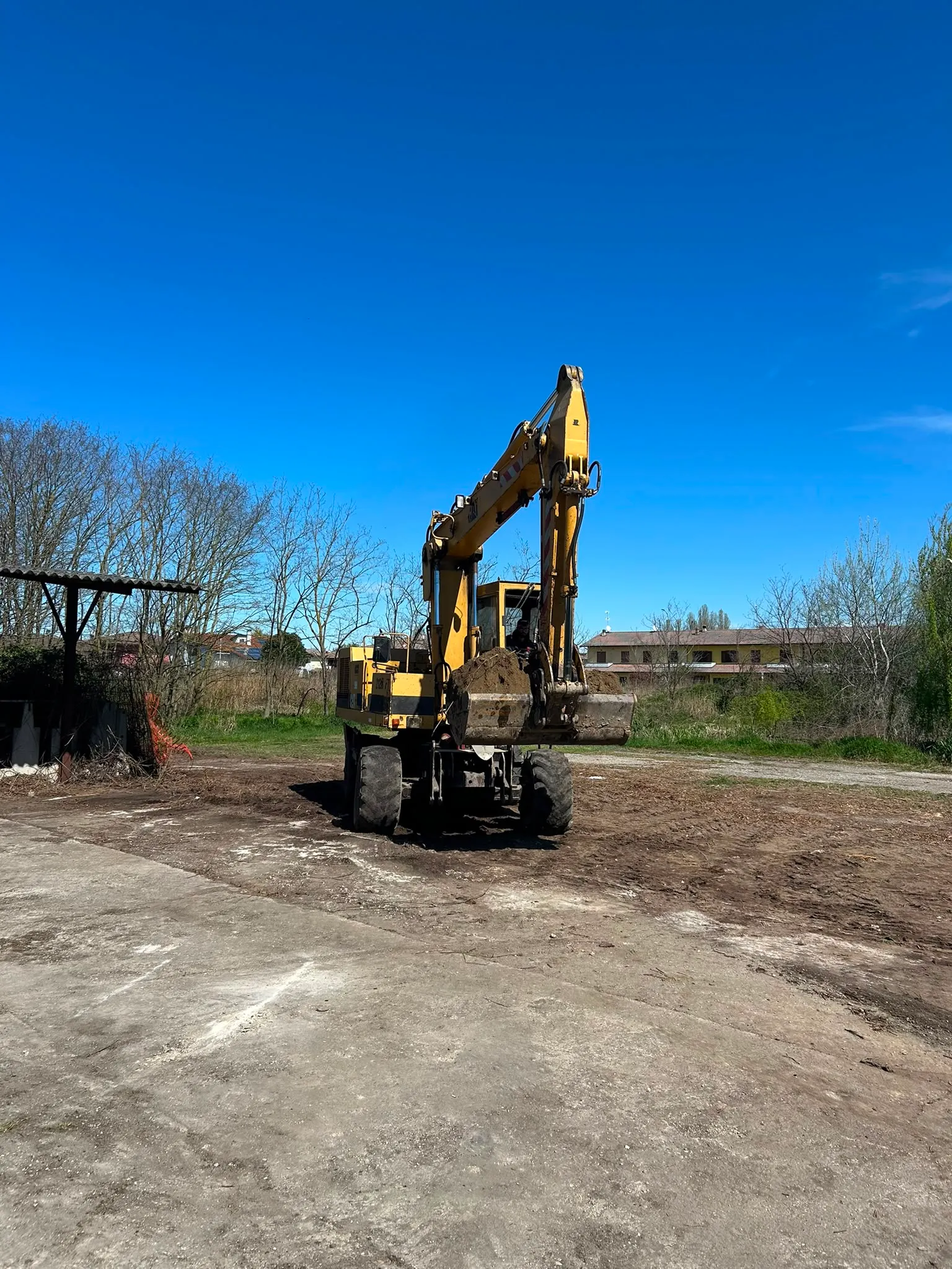 Escavatore impegnato nel movimento terra in area verde