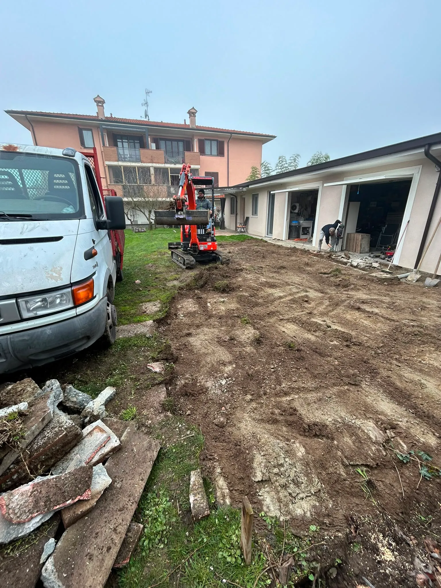 Mini escavatore al lavoro in un cortile residenziale
