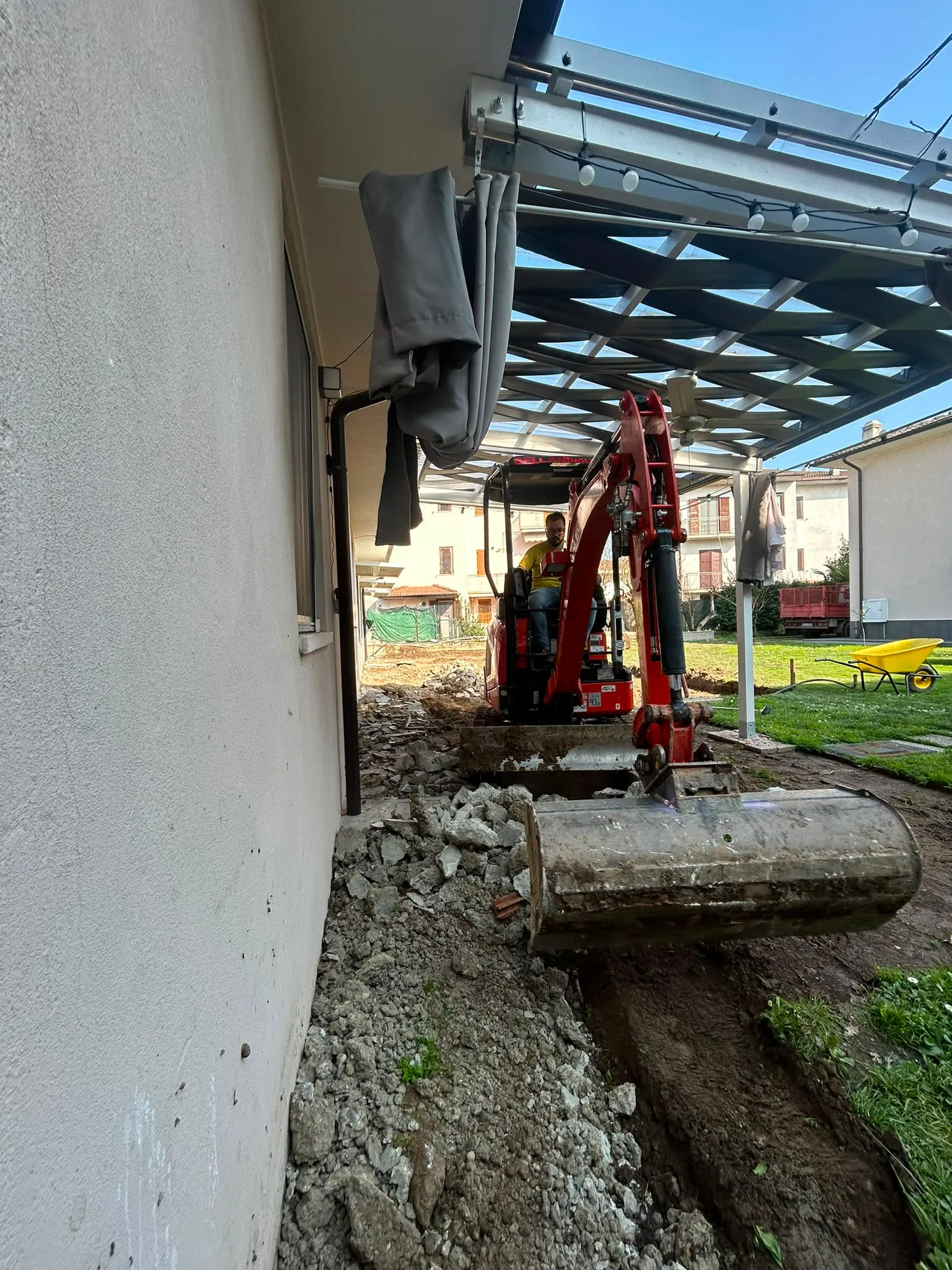 Scavo vicino a un'abitazione con mini escavatore